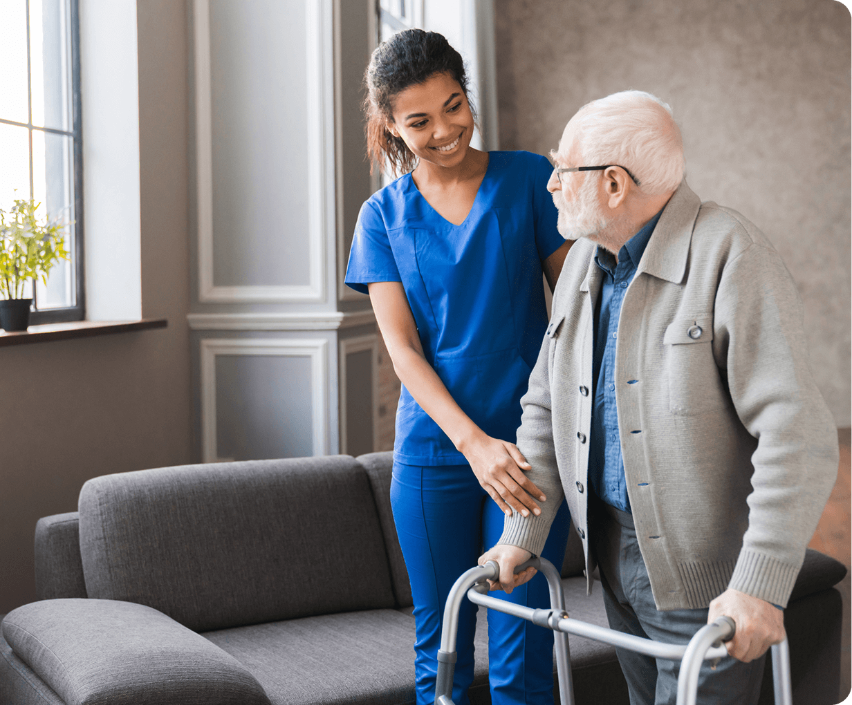Caregiver assisting elderly man with walker indoors.